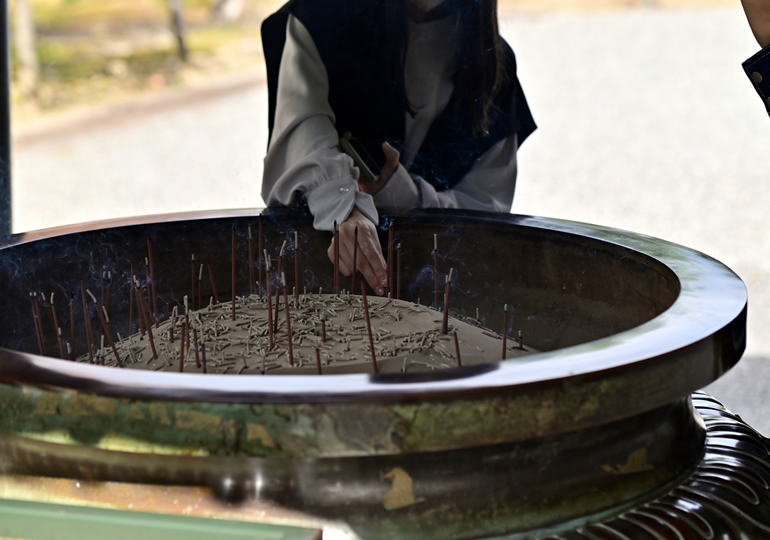 菩提寺で線香をあげる檀家の女性