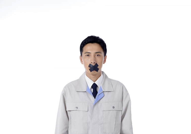 口にバツのマークを付けた男性