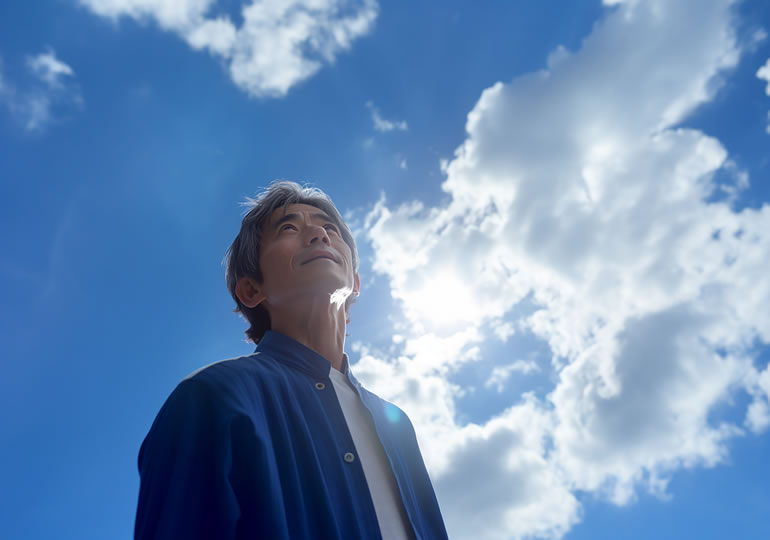 墓じまいをして笑顔で空を眺める男性
