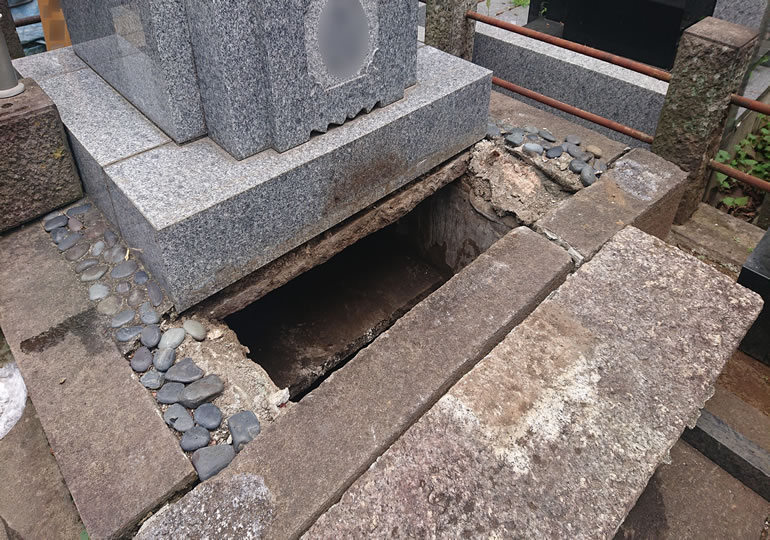 墓じまいの為にカロートを開けて骨壺を取り出す作業