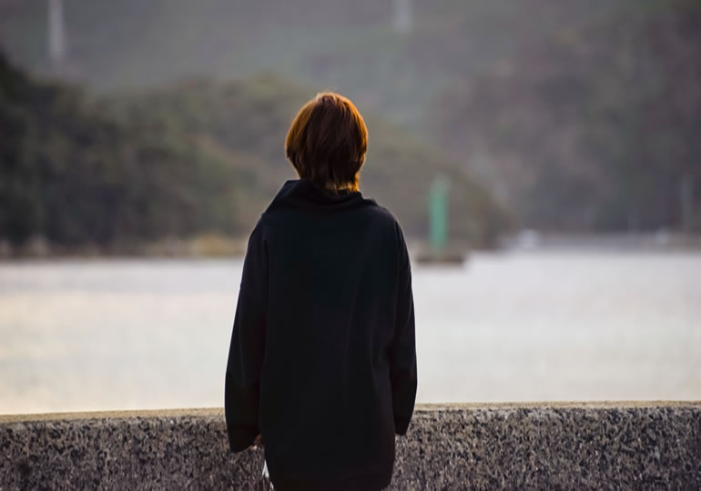 墓じまいして海を見つめる女性