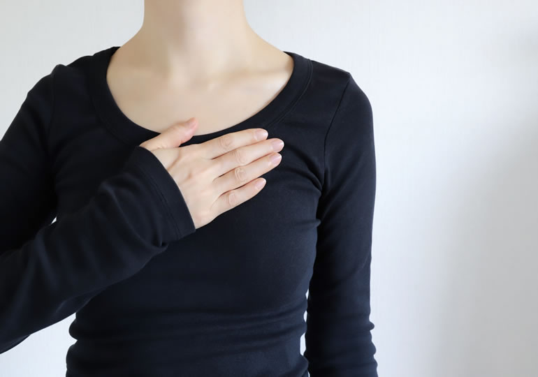 胸に手を当てる女性