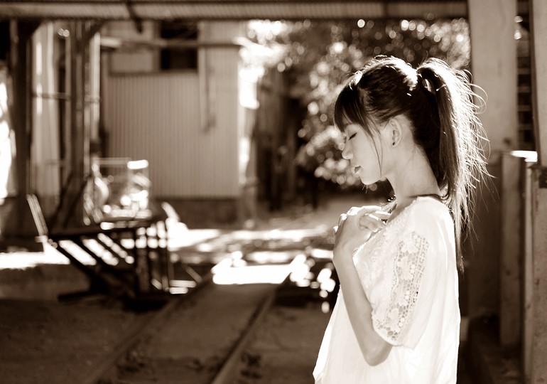 胸に手を当て考え込む女性