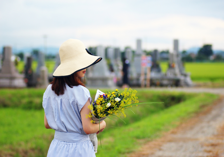 地方の墓参りをする若い女性