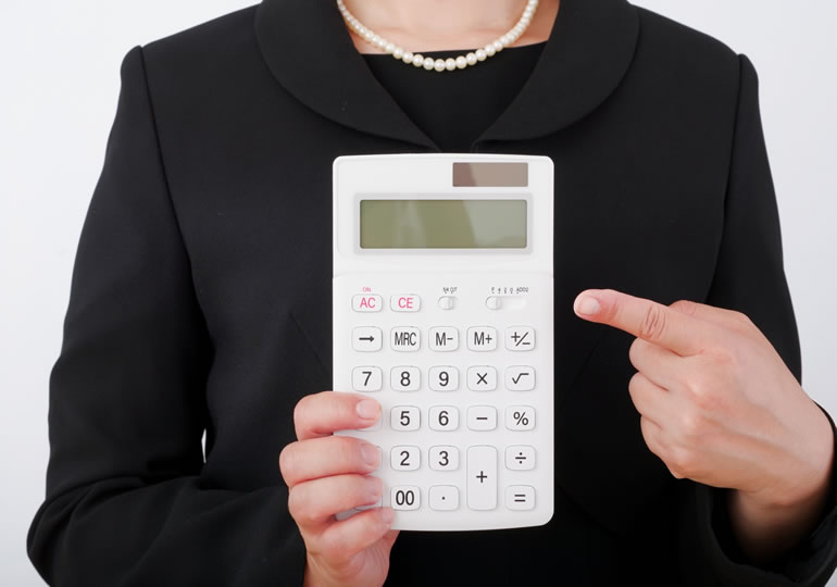 喪服姿で計算機を持つ女性