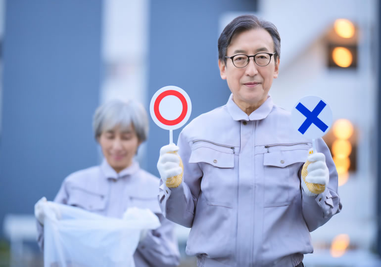 ゴミ捨て場で遺骨の処分と供養の違いを説明する高齢者