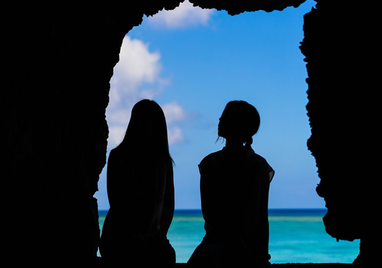 海を眺める女性の後ろ姿