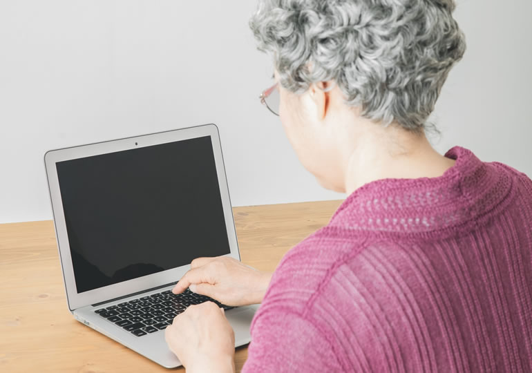 パソコンで終活をする高齢の女性