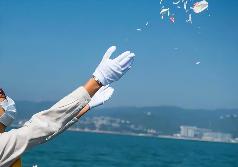 散骨後に献花を撒く女性