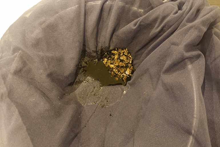 丁寧に遺骨を骨壺から取り出す画像