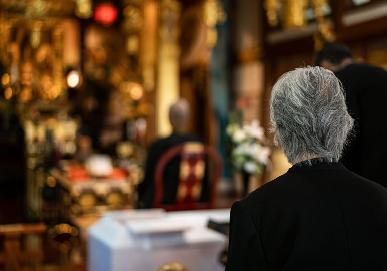 盛大な葬儀会場にいる男性の後ろ姿