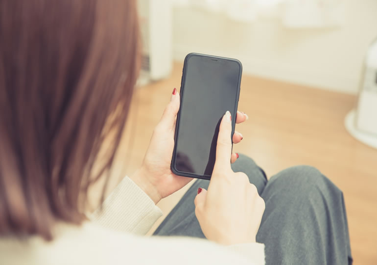 スマートフォンでペット供養業者を探す女性