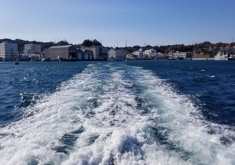 沖合に向かう散骨船から眺める漁港の街